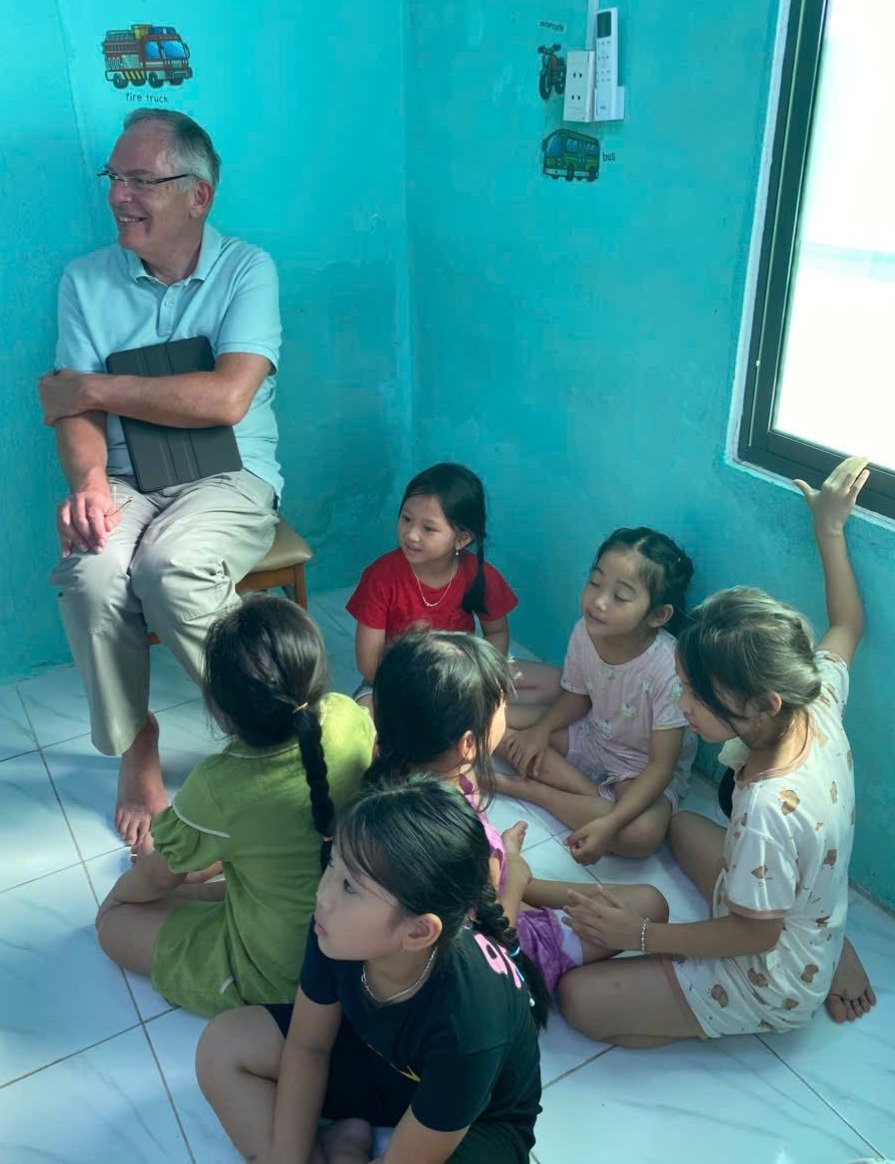 Speaker seated with children during the session